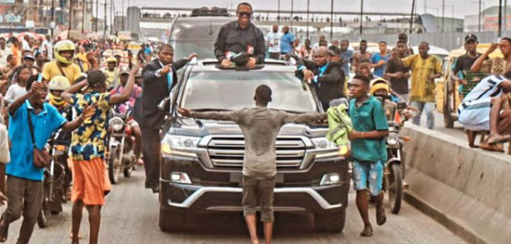 Quadri standing in front of Peter Obi's convoy during his presidential campaign last two years